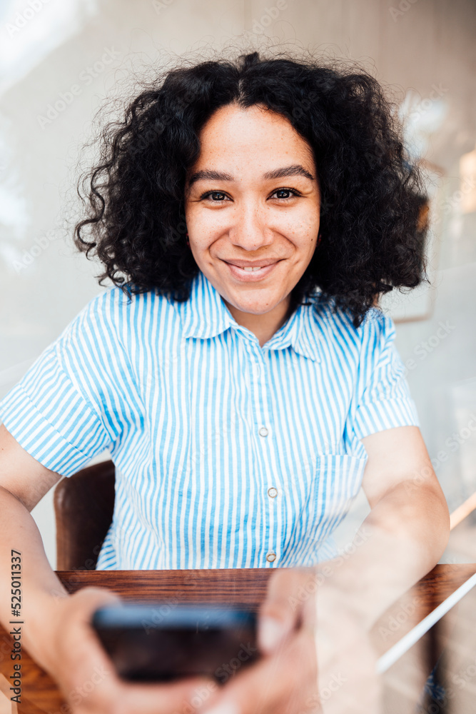 Happy woman with mobile phone sitting at table Happy woman with mobile phone sitting at table