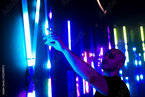 Man touching illuminated lights on wall