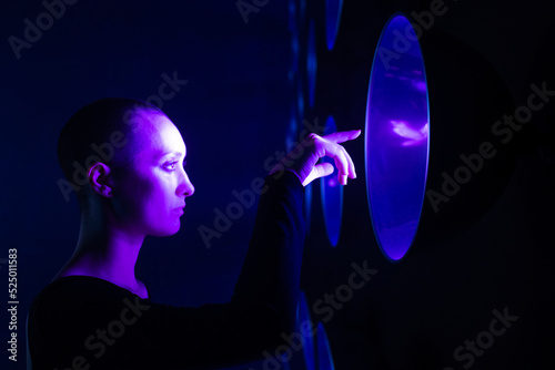 Young woman touching neon light photo