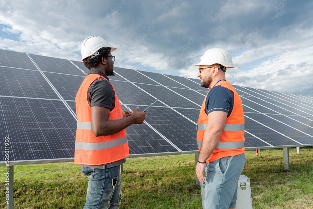Multiracial engineers having discussion at solar station Multiracial engineers having discussion at solar station