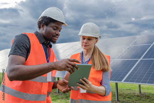 Engineer and co worker sharing tablet PC at solar station photo