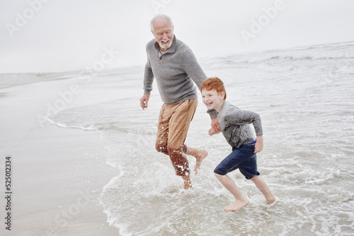 Grandfather playing with grandson at the sea