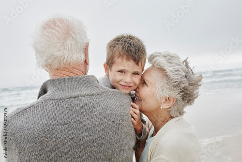 Happy grandparents spending quality time on the beach with grandson photo