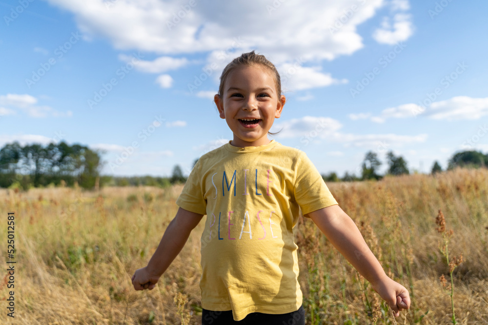 Cheerful girl with closed fist standing at field Cheerful girl with closed fist standing at field