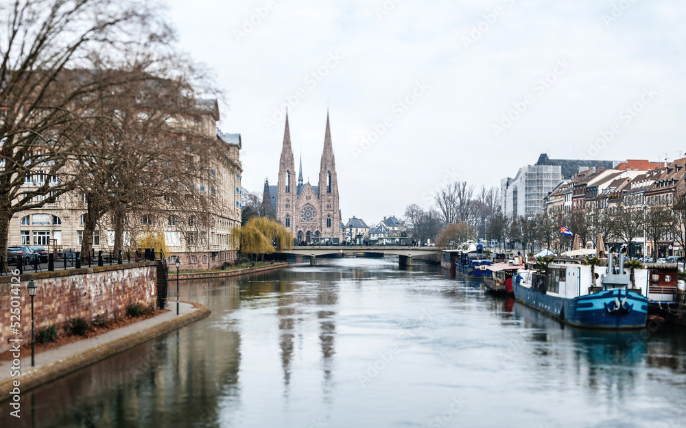 Tilt-shift lens used to photograph the city center of Strasbourg with Eglise reformee Saint-Paul and Ill river Pont Royal and large boats vis-a-vis of Escape building