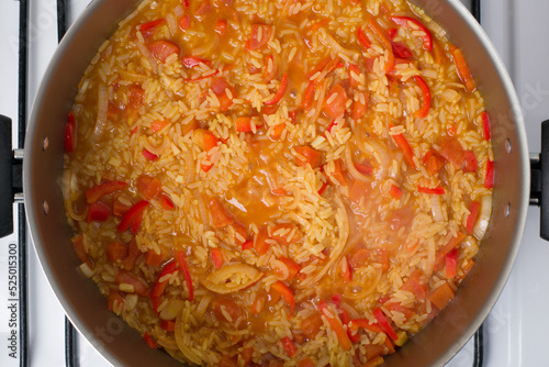 Pot with Valenciana rice stewing on stove photo