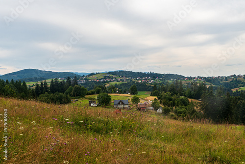 Jaworzynka village with hilly landscape with mix of meadows and forest covered hills around in Poland photo