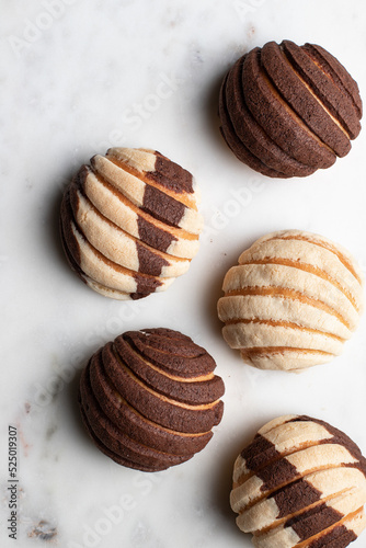 Tasty Mexican conchas on plate in kitchen