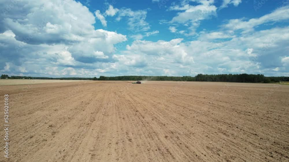 Agriculture, farm tractor plow the earth in field, dust in the field, view from height, grain sowing, countryside landscape. Agriculture, farm tractor plow the earth in field, dust in the field, view from height, grain sowing, countryside landscape.