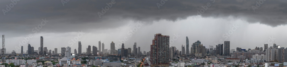 Modern city under dramatic stormy rainy clouds.