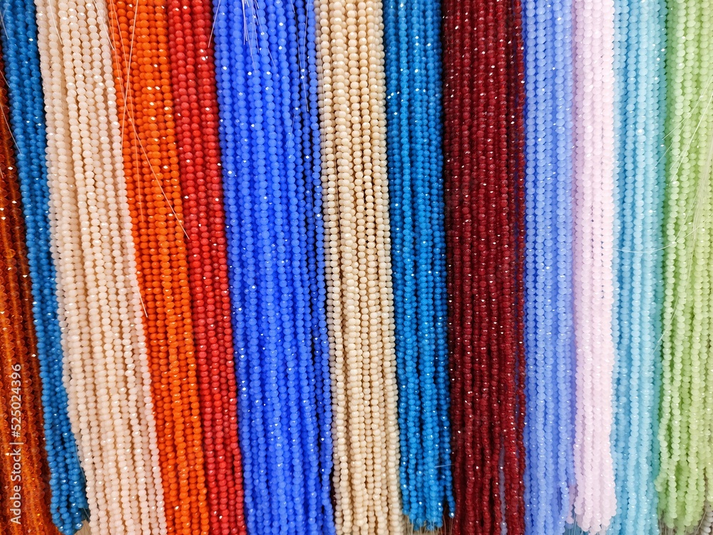 multi-colored beads hang in rows on the wall