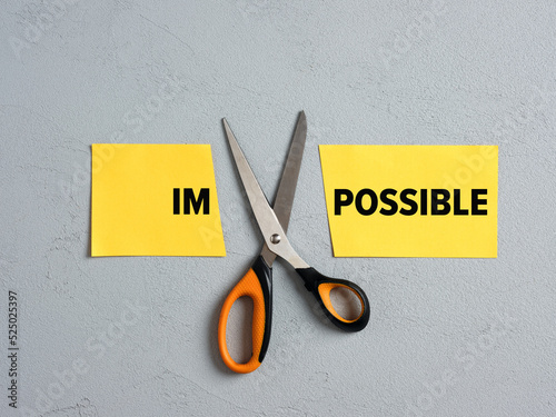 Scissors Cutting off the Word impossible and transforming into possible. Concept of possibility, positive thinking, confidence, optimism