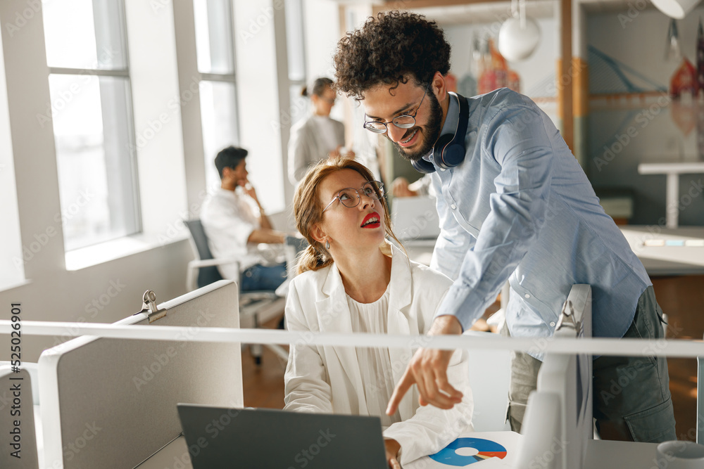 Obraz premium Businesspeople working together in bright office, sitting at desk
