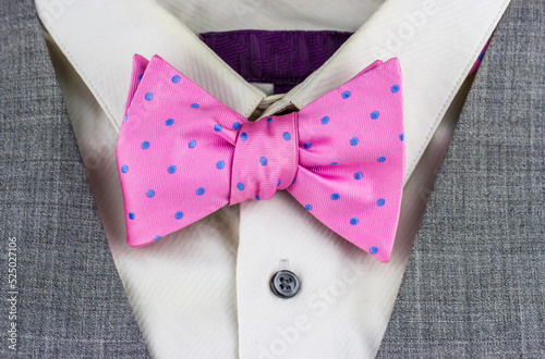 Close-up view of pink bow tie with white shirt and jacket