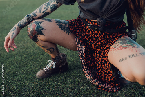 Stylish millennial tattooed woman on lawn photo