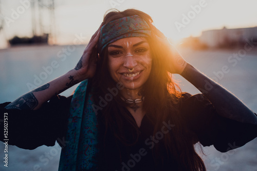 Happy young brunette with ritual white makeup and piercing on street photo
