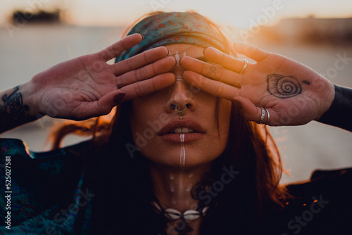 Brunette with ritual white makeup and piercing on street