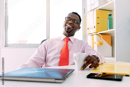 Cheerful black entrepreneur in formal apparel in office photo