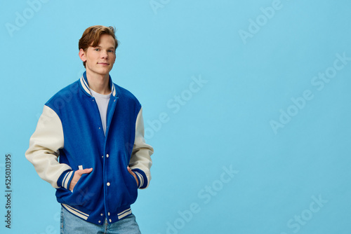 handsome, fashionable guy posing in a bomber jacket holding his hands in his pockets