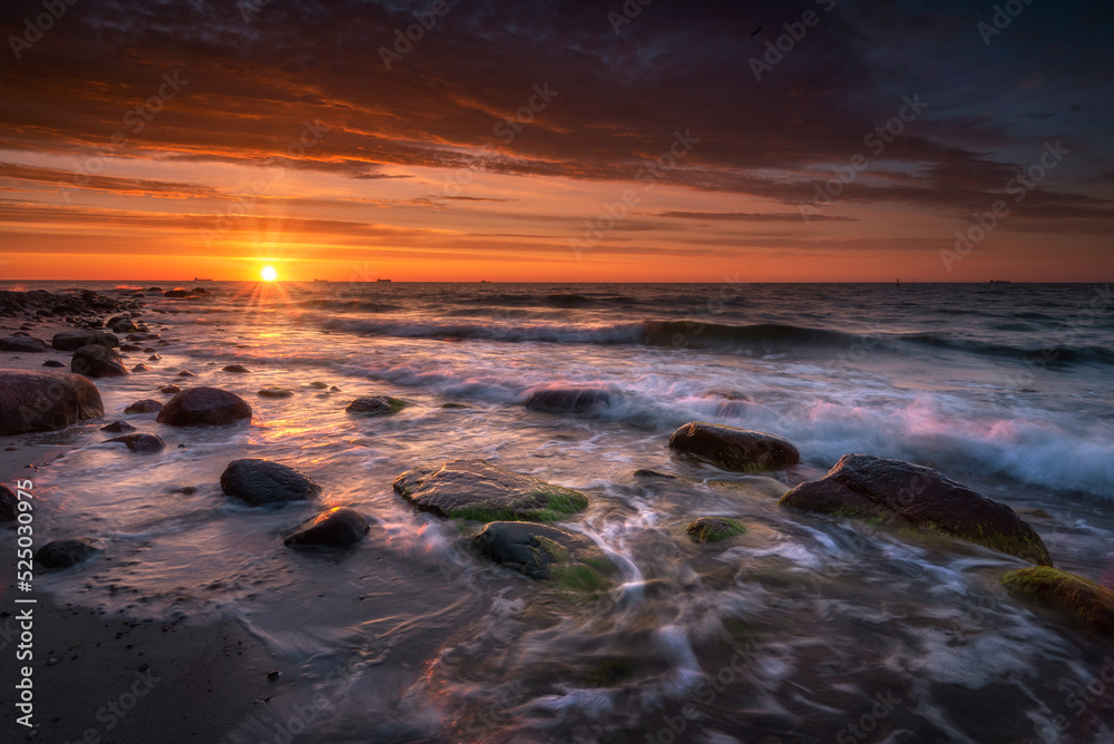 Morze bałtyckie - wschód słońca na plaży Gdynia Orłowo z widokiem na fale 
