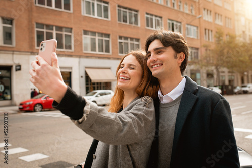 Loving young couple taking selfie on street