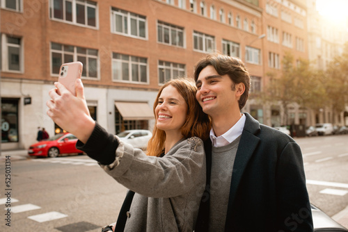 Loving young couple taking selfie on street