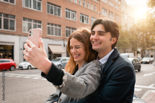 Loving young couple taking selfie on street