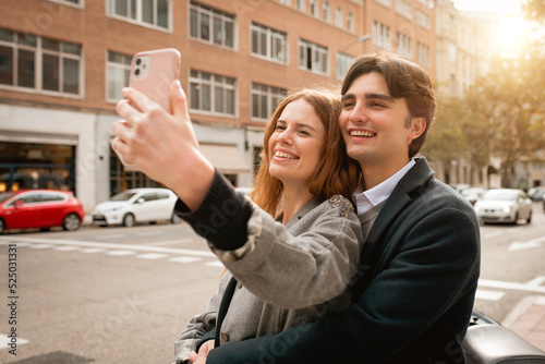 Loving young couple taking selfie on street
