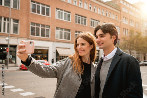 Loving young couple taking selfie on street