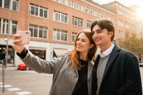Loving young couple taking selfie on street