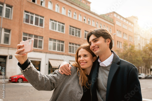 Loving young couple taking selfie on street