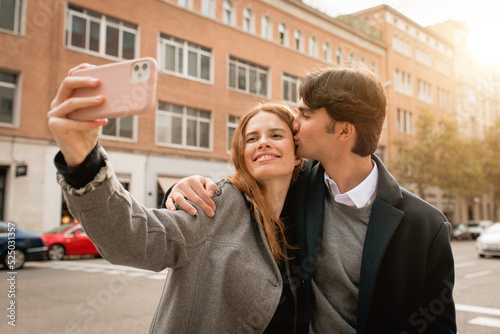 Loving young couple taking selfie on street