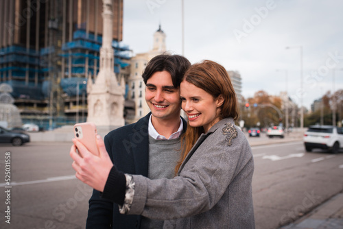 Loving young couple taking selfie on street