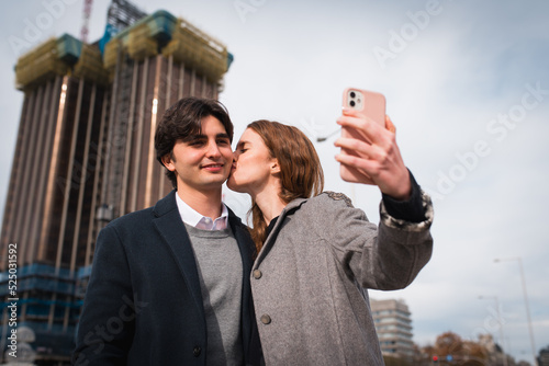 Loving young couple taking selfie on street