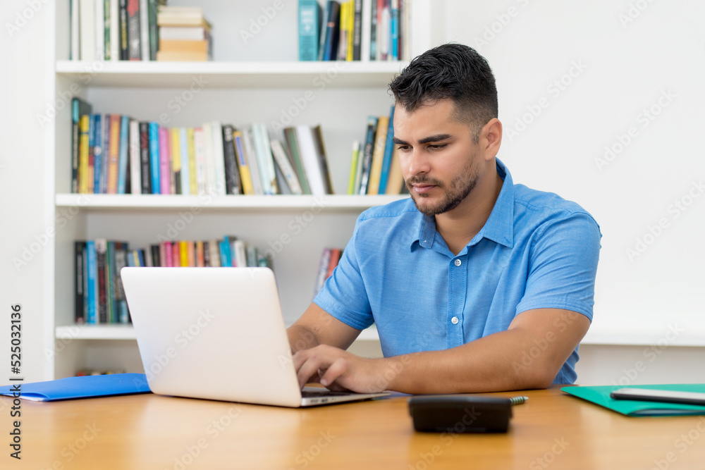 Hispanic hipster man with beard working with concentration at computer Hispanic hipster man with beard working with concentration at computer