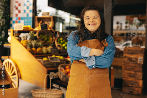 Cheerful shop employee with Down syndrome smiling at the camera