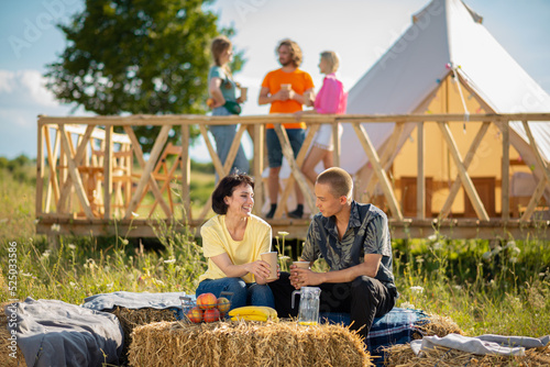 Foto Great looking couple while sitting on the haystack in the middle of campsite the