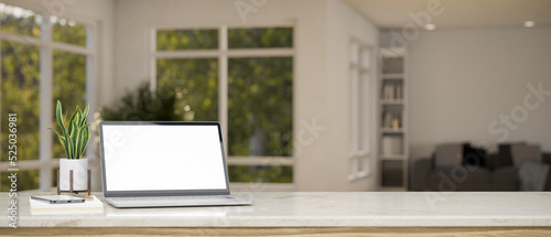 White marble tabletop with laptop mockup and copy space over blurred living room in background.