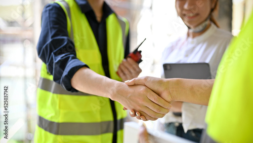 close-up, Male engineer shaking hands with a businessman in the construction site.