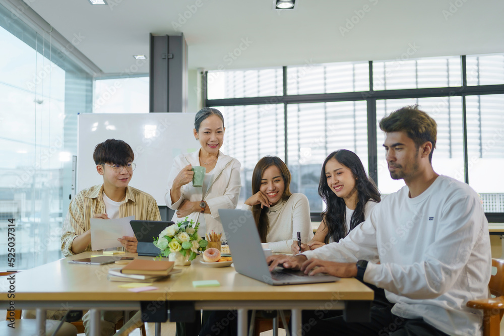 Group of Asian business people meeting, consulting and planning business on investment and market analysis for business development there are various analytical data document and using a laptop.