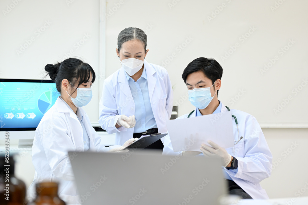 Team of professional Asian scientist in white gown having a medical research meeting in the lab. Team of professional Asian scientist in white gown having a medical research meeting in the lab.