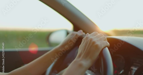 Close up female hands driving car outside city. Girl travels by car. Slow motion