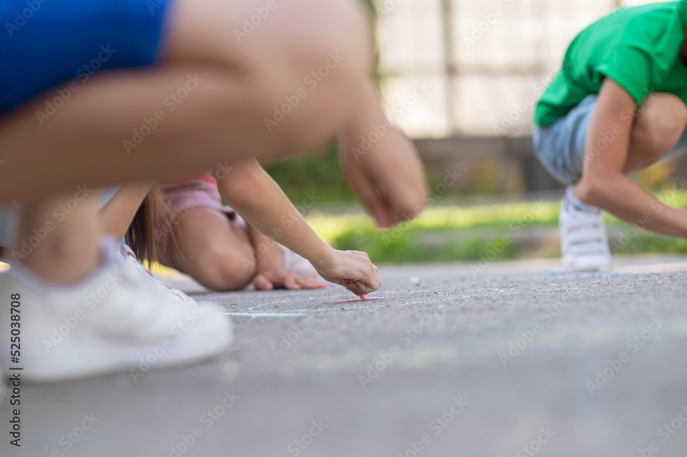 Naklejka premium Children painting on asphalt, no face