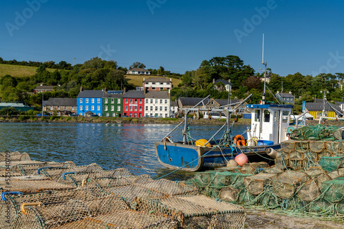 Tableau sur toile old wooden fishing boat and fishing nets and crab traps in Bantry Bay withe down