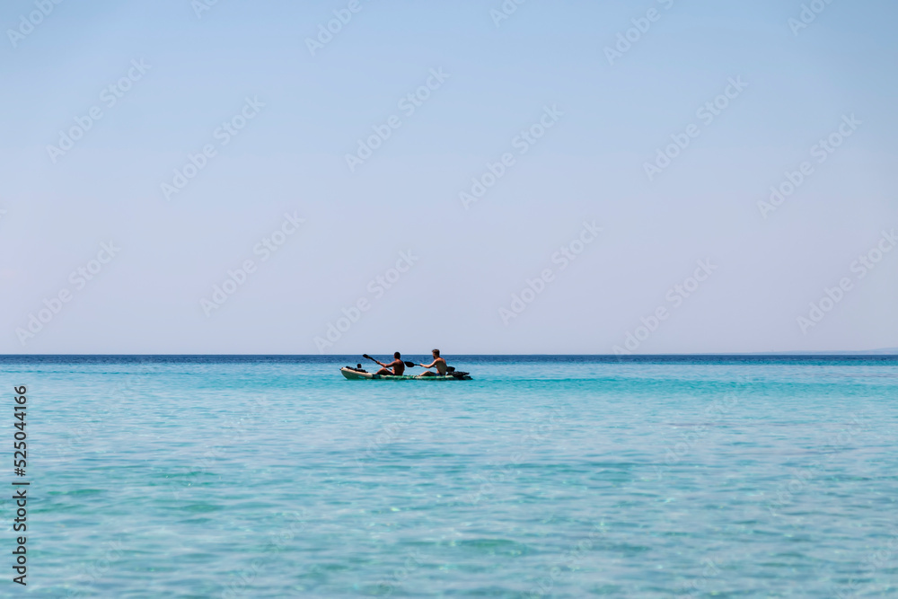 Happy two teenagers kayaking together in amazing clear water of Aegean sea.Happy family adventures concept