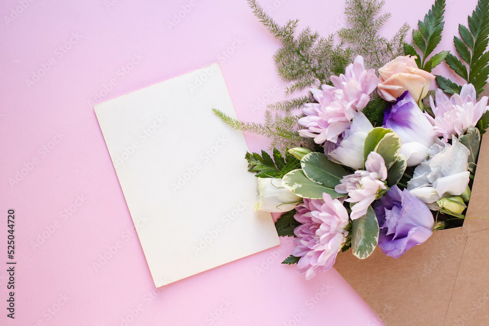 Obraz premium Minimalistic card mockup with white eustoma flowers. Workspace. Wedding invitation cards, craft envelopes, lisianthus with copy space. Overhead view. Flat lay, top view 