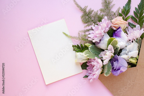 Minimalistic card mockup with  white eustoma flowers. Workspace. Wedding invitation cards, craft envelopes, lisianthus with copy space. Overhead view. Flat lay, top view  © arymer