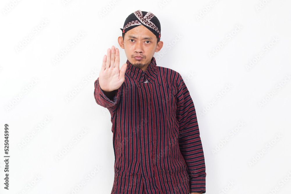 asian man with javanese traditional cloth lurik with open hand doing stop sign with serious expression defense gesture isolated on white background asian man with javanese traditional cloth lurik with open hand doing stop sign with serious expression defense gesture isolated on white background
