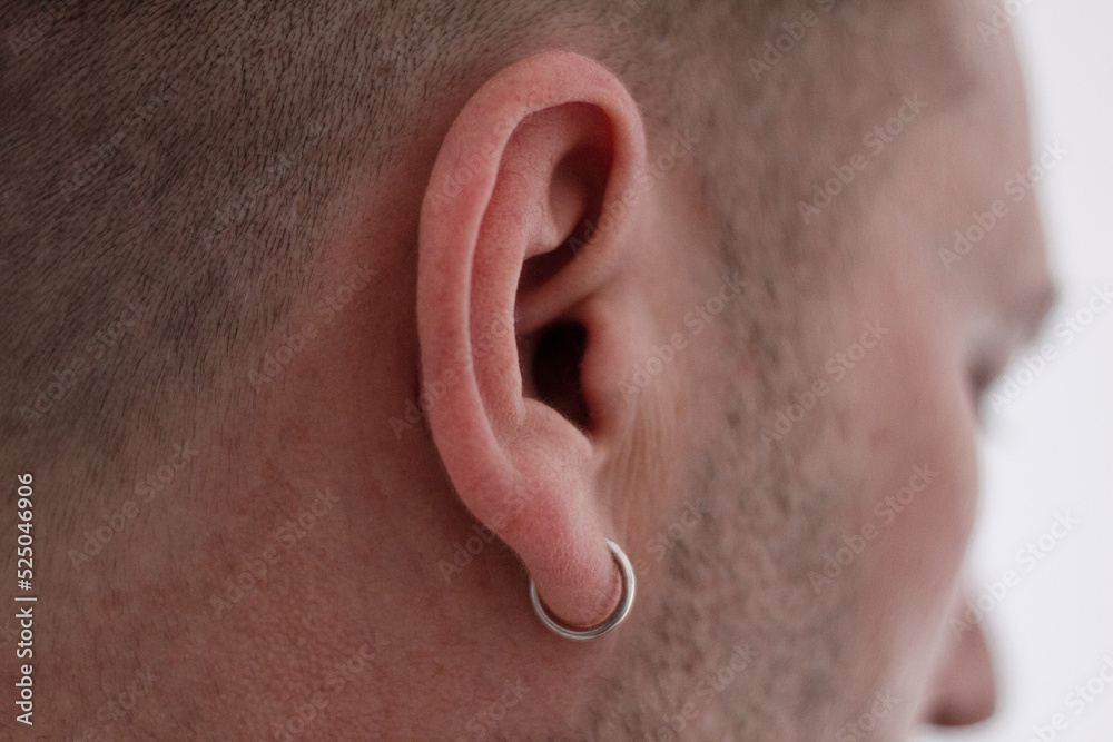 Earring in the ear, Close-up, Piercing in the ear Men Earring in the ear, Close-up, Piercing in the ear Men