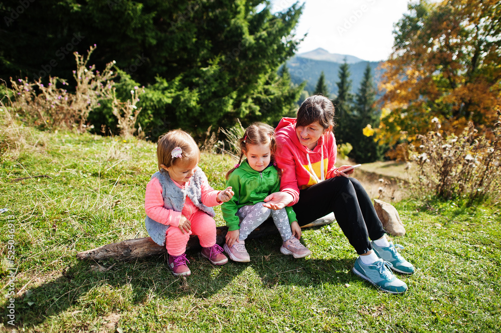 Mother with daughters enjoying in the mountains.The concept of family travel, adventure, and tourism. Lifestyle and hiking autumn vacations outdoor.